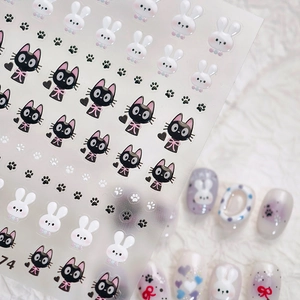 Cute black cat and white rabbit embossed nail stickers with paw prints on white fabric