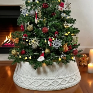 Detailansicht der weißen gestrickten Weihnachtsbaumdecke in gemütlicher Wohnzimmeratmosphäre