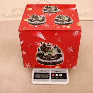 Detailed weight measurement showing 676g for the Christmas music box in its red gift box
