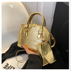 Detail of gold crocodile embossed shell bag set with matching envelope pouch and top handles