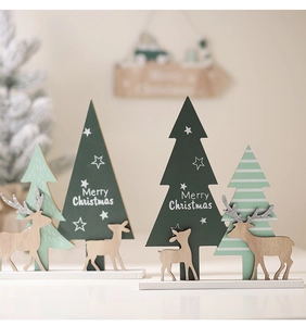 Makro-Detail von Holz-Weihnachtsbaum-Deko mit weißem Merry Christmas Schriftzug und Elch