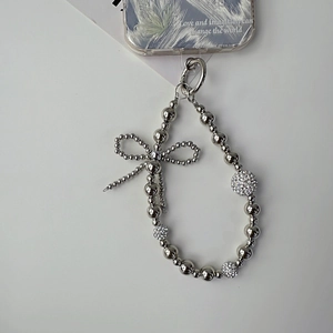 Detail of silver beaded phone strap featuring metal bow and crystal studded spheres