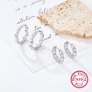 Close-up of 925 sterling silver hoop earrings with round and rectangular zircon stones