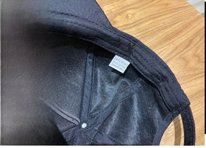 Detail of 100% cotton inner sweatband and washing label of a black baseball cap