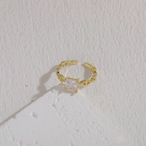 Detail of a 14K gold plated cubic zirconia ring on stone texture background