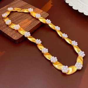 Detailed shot of golden vintage necklace featuring elegant white pearl flower motifs