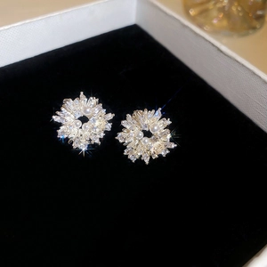 Macro detail of gold flower earrings with crystals and pearls on black velvet display