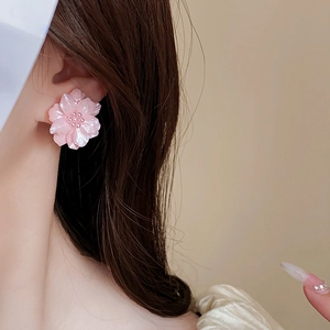 Gros plan d'une boucle d'oreille fleur rose en acrylique avec perle sur un mannequin