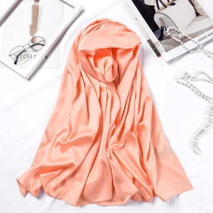 Close-up of peach satin silk hijab scarf showing premium matte texture and soft sheen
