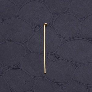 Golden stainless steel T-pins for DIY earring jewelry making on dark textured background