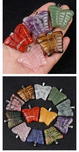 Macro detail of various 30x35mm natural crystal butterfly pendants with silver metal clasps