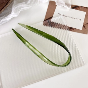 Minimalist green marble pattern U-shaped hair pin on elegant textured glass surface