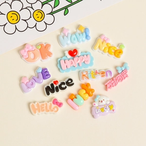 Macro shot of 3D resin DIY charms with colorful slogans like LOVE and HAPPY in pastel tones