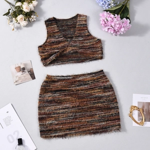 Ensemble en maille pelucheuse à rayures avec crop top et mini-jupe posé sur fond gris neutre