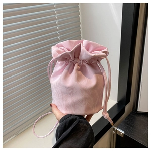 Detail view of pink drawstring bucket bag with elegant water ripple pleated texture
