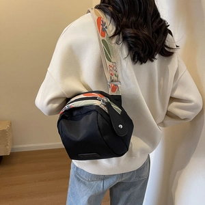 Black canvas shell crossbody bag with floral embroidered strap for casual daily use