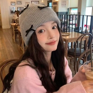 Grey knit beanie featuring chic black velvet bows for a sweet winter fashion style