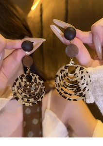 Macro shot of resin wood geometric earrings with leopard print and black bead details