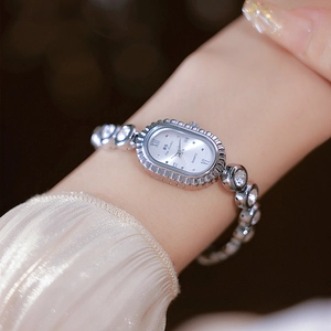 Close-up of elegant silver oval quartz watch with rhinestone accents on a female wrist