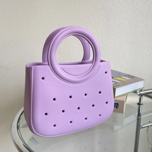Détail du sac cabas lilas en EVA avec poignée ronde unique sur support en verre