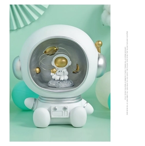 Close-up of astronaut helmet music box with LED starry lights and resin base