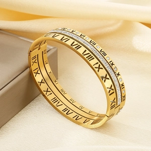 Close-up of gold titanium bracelet with Roman numerals and sparkling center rhinestones