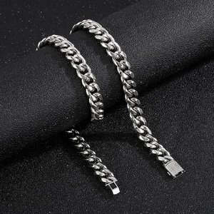 Macro shot of silver Cuban link chains with diamond CNC box clasp on black background