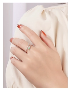 Detail of 925 sterling silver snake ring with green zircon eyes and white stones