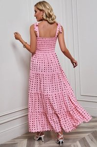 Detail of a pink geometric print sundress featuring thin straps and an elastic ruched back