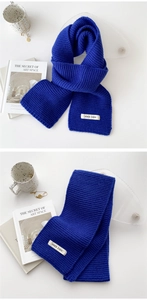 Detail of blue knitted winter scarf with VOICE CHOO label on high-quality fabric texture