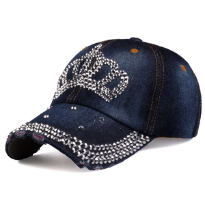 Detail of crown rhinestone embellishment and distressed denim on the blue baseball cap