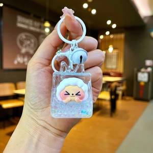 Detailed close-up of acrylic liquid sand keychain with cute sheep inside and white bell
