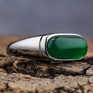 Macro detail of oval green cat eye gemstone set in a vintage stainless steel ring band