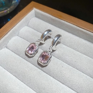 Macro detail of silver drop earrings featuring a rectangular pink zircon stone setting