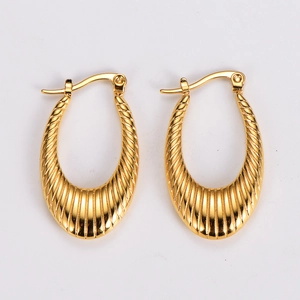 Detail of gold U-shaped earrings with vertical pleated texture and metallic finish
