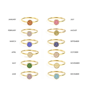 Set of twelve gold stainless steel birthstone rings with colorful cubic zirconia