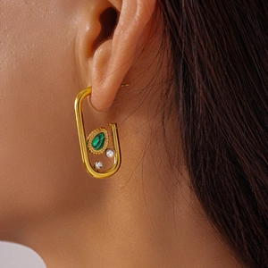 Close-up of U-shaped gold earring featuring malachite stone, pearl and zircon detailing