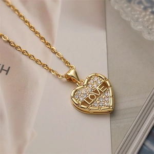 Macro shot of gold heart locket pendant with LOVE lettering and shiny zircons