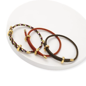 Close-up of adjustable woven cord bracelets with golden metal loops in multiple colors