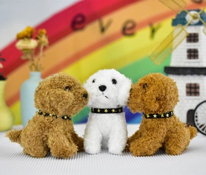 Detailed shot of three plush teddy dog pendants in brown and white with golden star collars