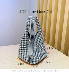 Detail view of silver rhinestone bucket bag showing 14cm x 17cm dimensions on wood