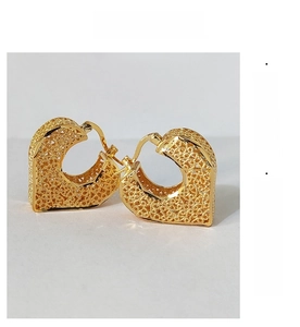 Detail of vintage heart hoop earrings with intricate gold-plated filigree hollow work
