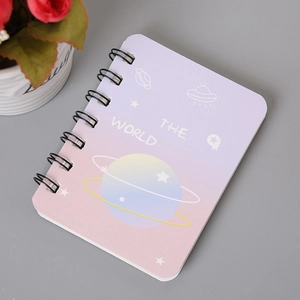 Detail of A7 spiral notebook featuring pink space theme cover and black metal binding