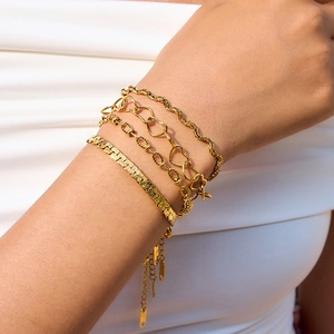 Detail of four-piece gold stainless steel heart and snake chain bracelets set for women