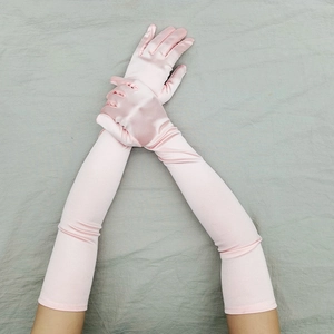 Dettaglio guanti lunghi in raso rosa che mostrano la texture liscia e la lucentezza elegante