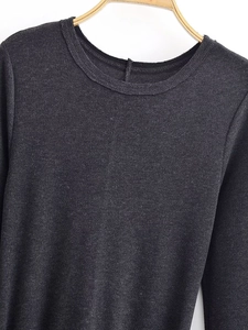 Detail of dark grey long sleeve dress showing fine knit fabric texture and round neckline
