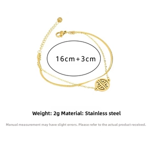 Detail view of gold double-layer snake chain bracelet with Chinese pattern pendant