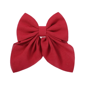 Detailed view of red floral pattern texture on a large fabric bow hair clip accessory