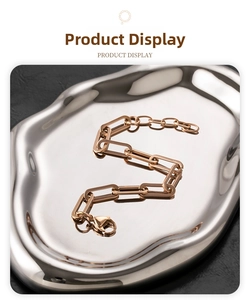 Detailed macro view of a rose gold paperclip chain bracelet on a sleek metal tray