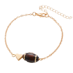 Détail du pendentif coeur doré et rugby marron pailleté sur une fine chaîne dorée